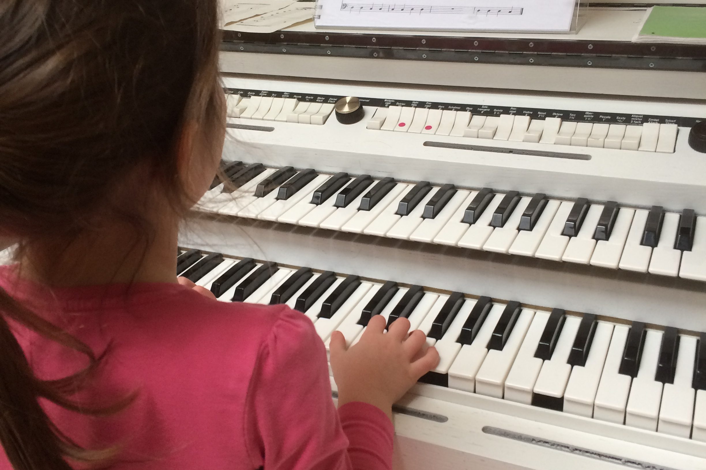 Kind spielt Orgel auf Manual
